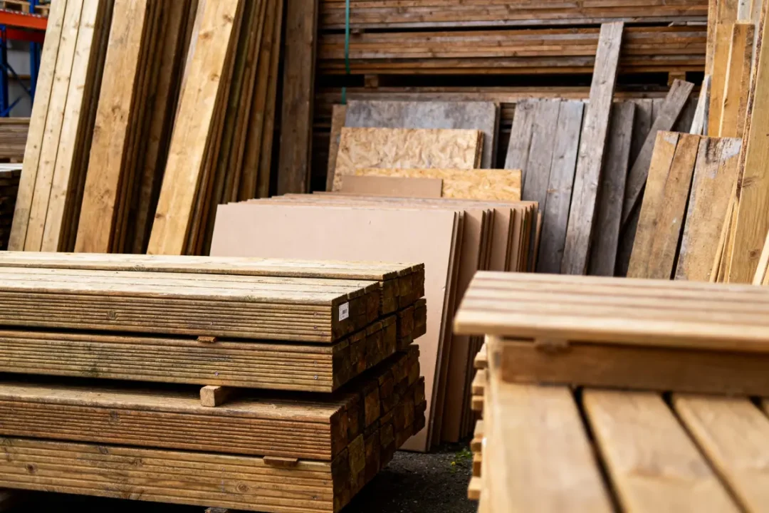 Piles de planches en bois et panneaux de contreplaqué dans un dépôt de matériaux de construction.